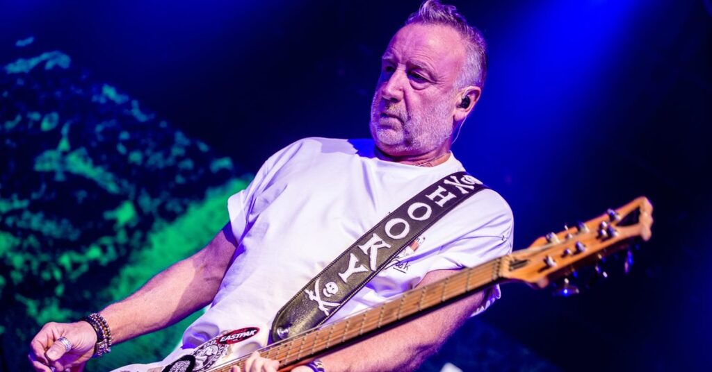 Peter Hook se apresentando ao vivo em São Paulo, com a plateia animada.